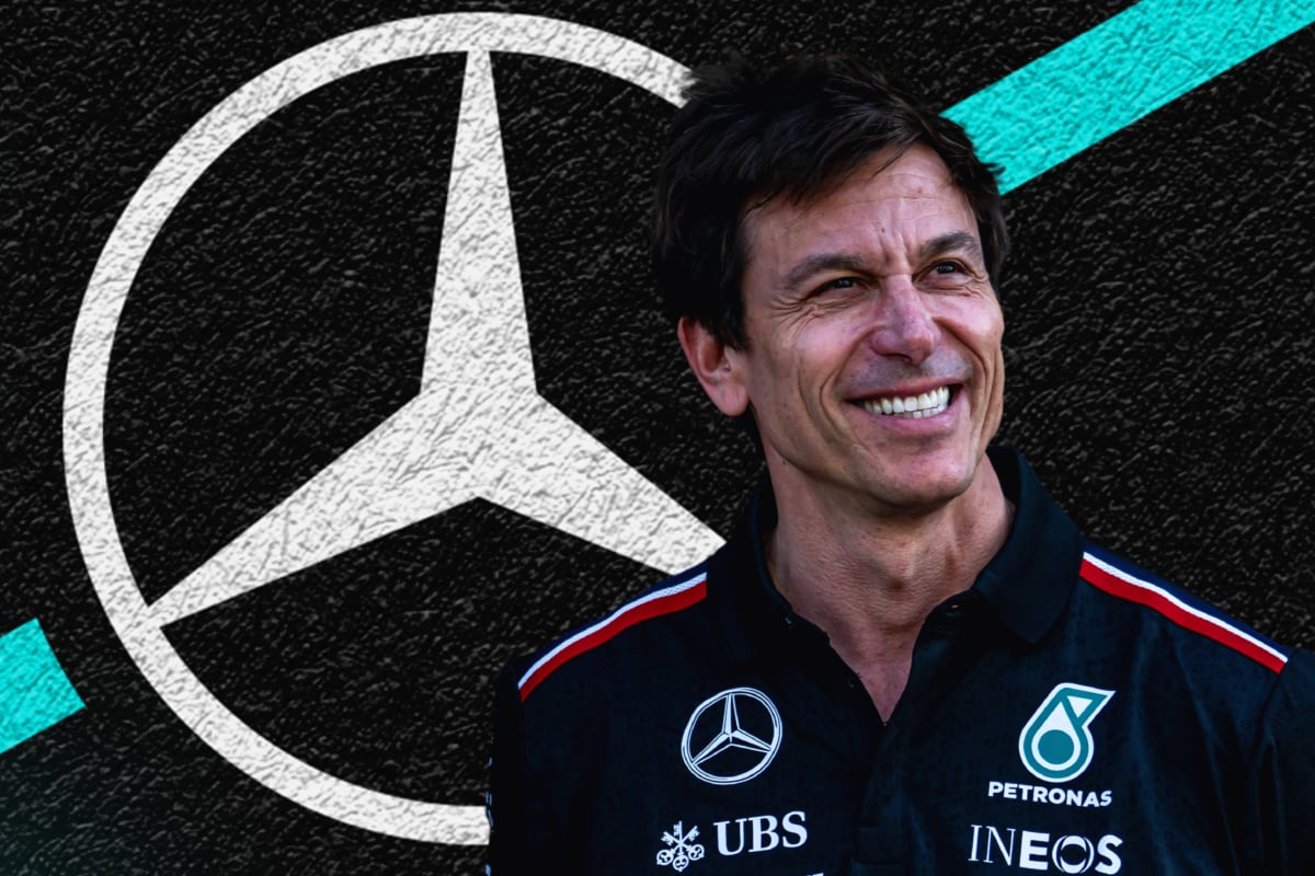Toto Wolff smiling with a Mercedes logo black, white and turquoise background