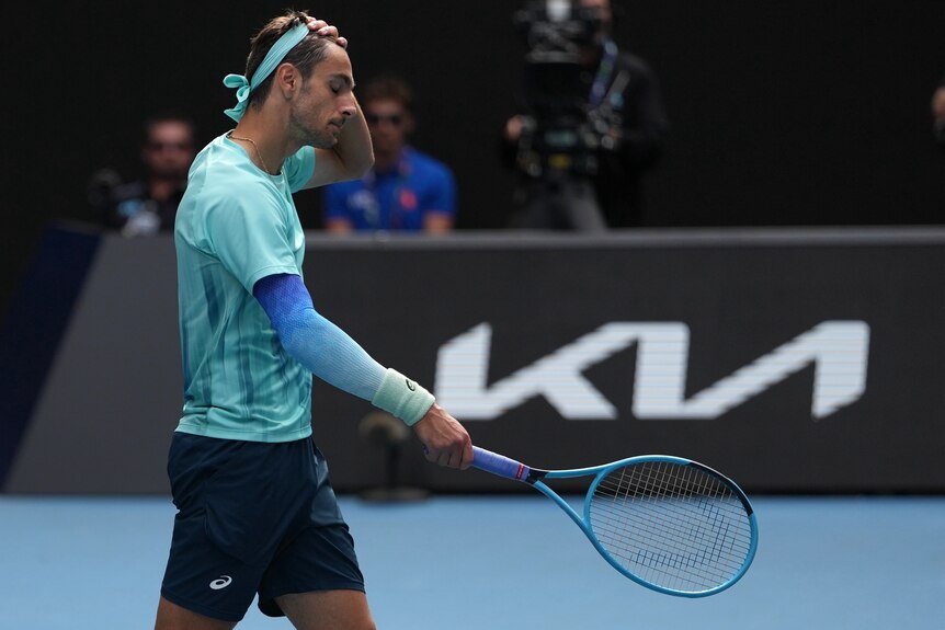 Lorenzo Musetti reacts after withdrawing from his Australian Open match against Novak Djokovic.