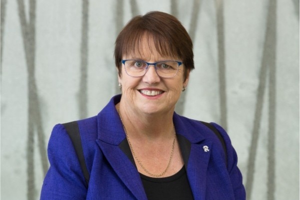 A woman smiles at the camera