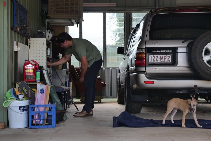 man in shed near car