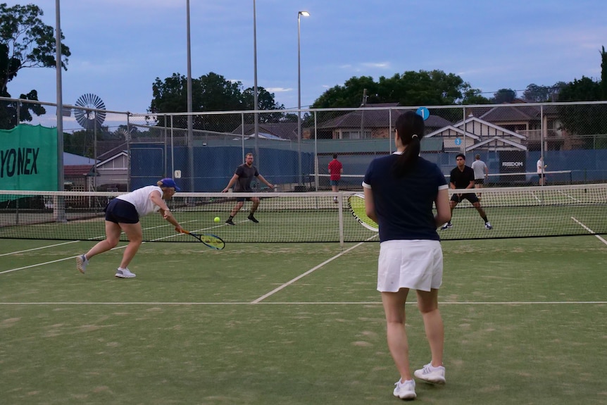 a game of doubles, two women playing two men