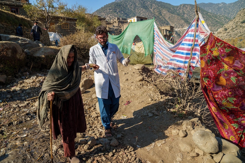 A doctor assists an elderly Afghan woman in Afghanistan.