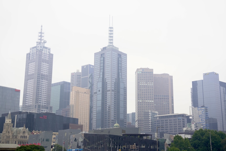 Very tall buildings covered in smoke