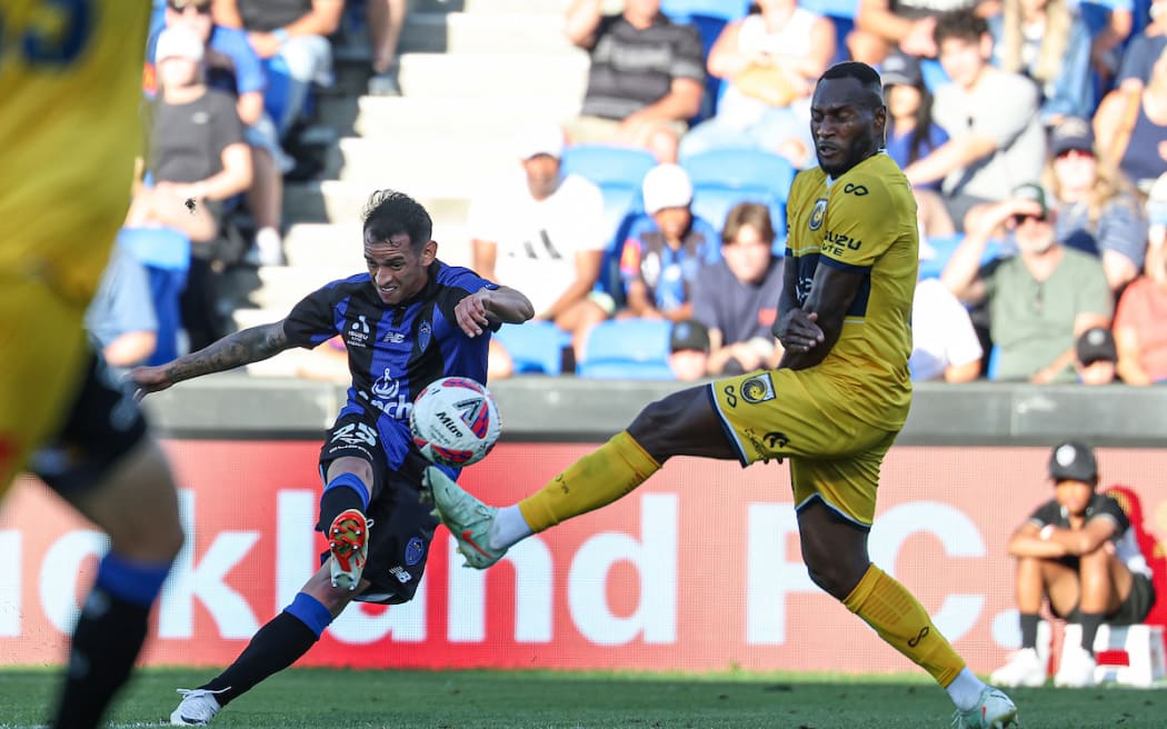 Auckland FC's Neyder Betancur shoots ahead of Central Coast Mariners Brian Kaltak.