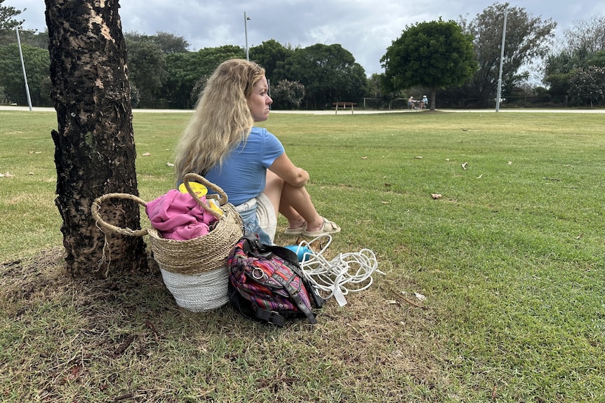 woman sitting near tree in park