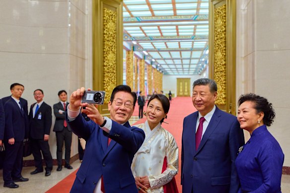 South Korean President Lee Jae Myung snaps a selfie with Chinese President Xi Jinping and their wives in the Great Hall of the People in Beijing on January 5, using the Xiaomi smartphone Xi gifted him at a summit last year. 