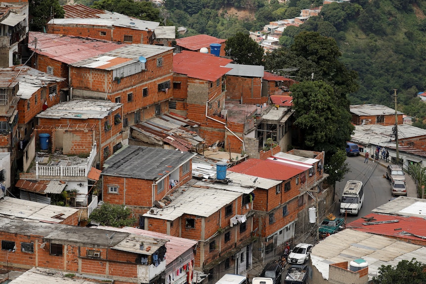 Red brick homes built close together on a hillside.