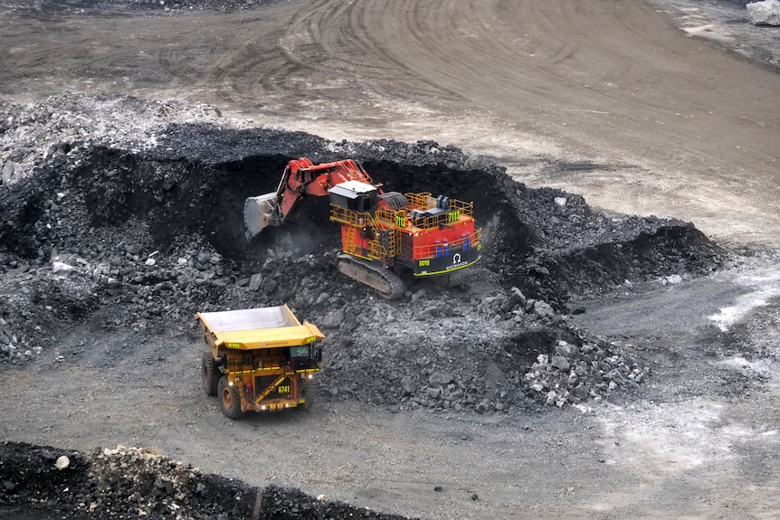 A mine excavator digs out a pile of lithium ore.