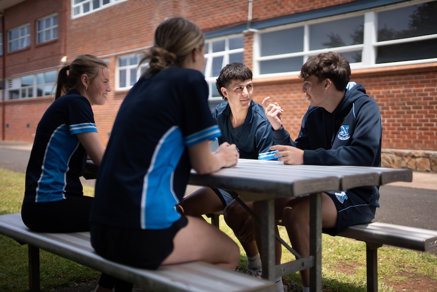 Students sit around the table.