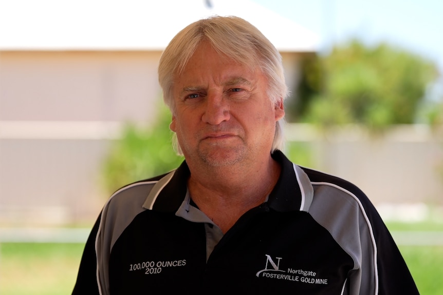Man with a blue shirt looks at the camera