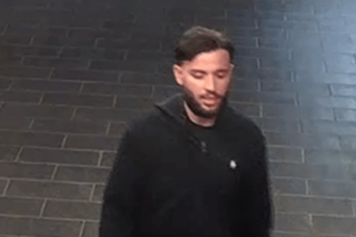 A photo of Adam Berguiga wearing a black hoodie and walking.