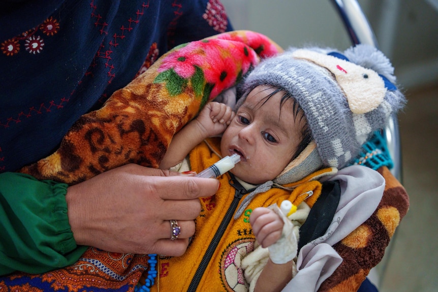 An Afghan mother feeds her baby through a tube.
