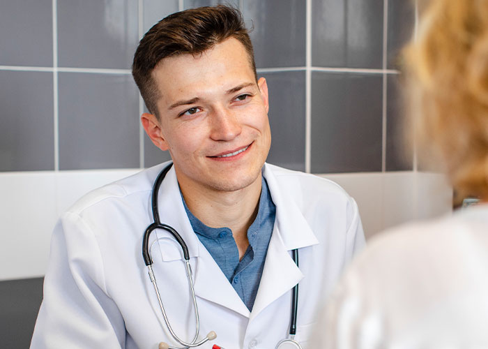 Young male doctor with stethoscope listening to patient, illustrating unprofessional things doctors have said to patients.