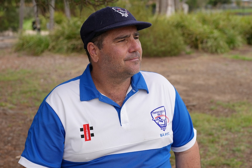 A man sitting on a bench outside.
