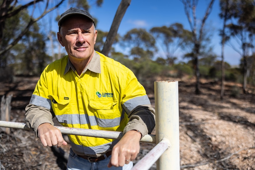 A mining executive in high-vis workwear in bushland.  