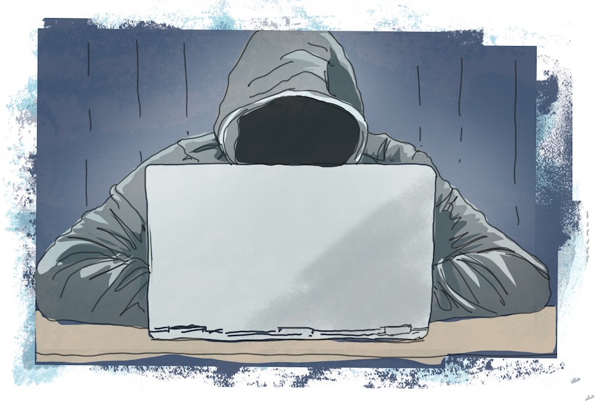 A man in a hoodie, using a laptop.