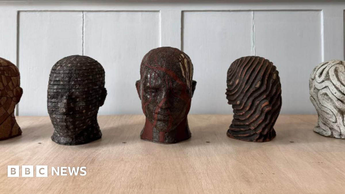 Sketches and maquettes of Joseph Hillier's head busts for the art train in Watlington. All five of them have different designs and are placed on a wooden table in a room.