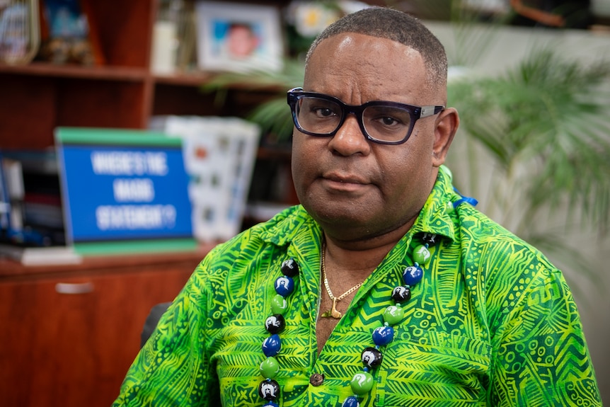 Torres Strait Islander man wearing bright green shirt and glasses