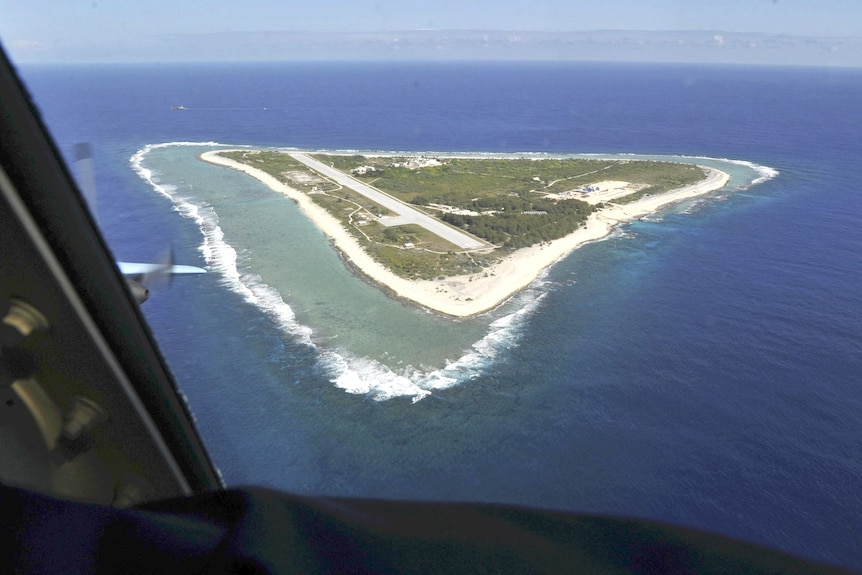 A roughly triangular-shaped island sits surrounded by blue ocean with a large airstrip on it