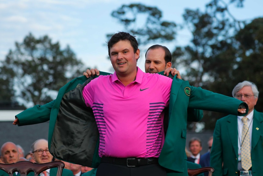 2018 Masters winner Patrick Reed puts on his winners green jacket