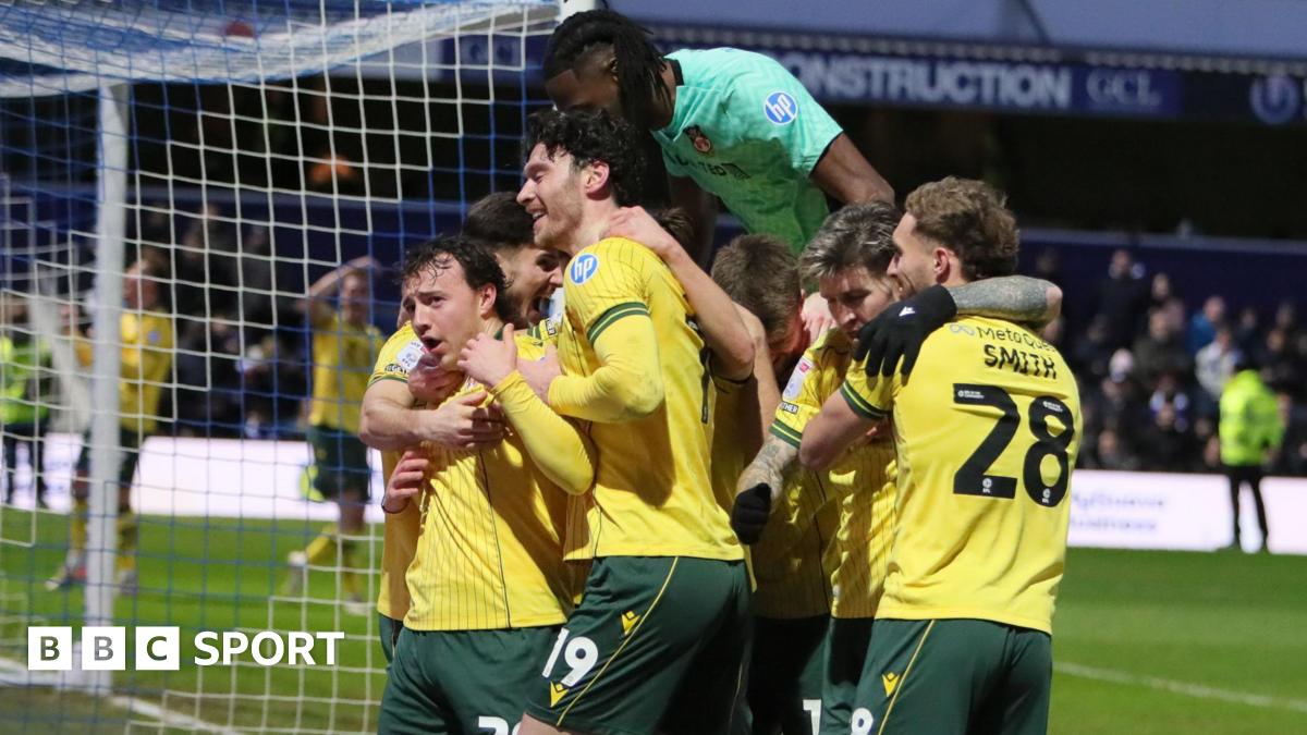 Wrexham players in their yellow away shirts celebrate with goalscorer Ollie Rathbone