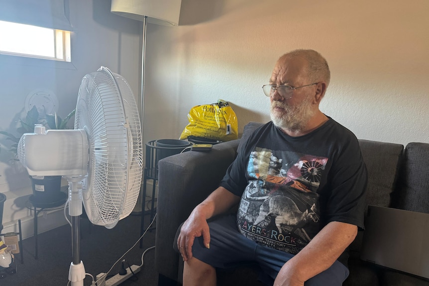 John Bieganski sits in front of a fan.