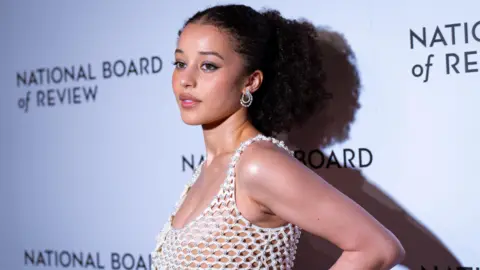 Reuters Chase Infiniti posing for photos in front of a National Board of Review-branded backdrop