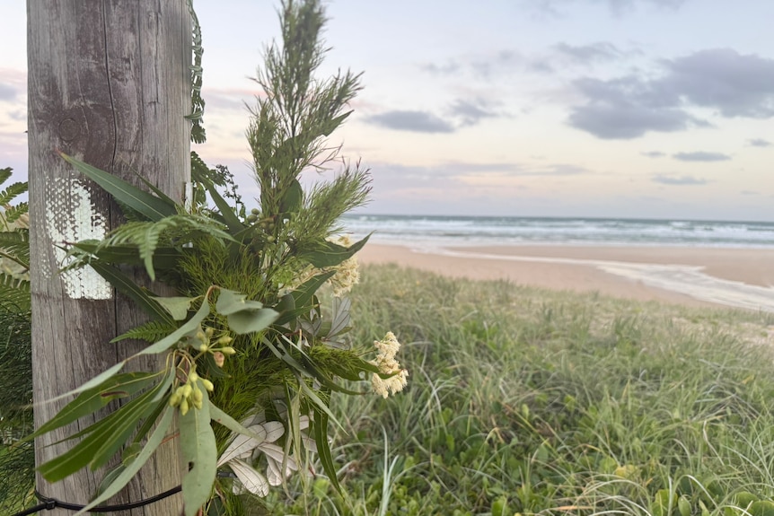 Flowers on a pole near a beach