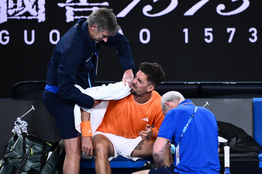 Thanasi Kokkinakis gets treatment on his shoulder during a tennis match