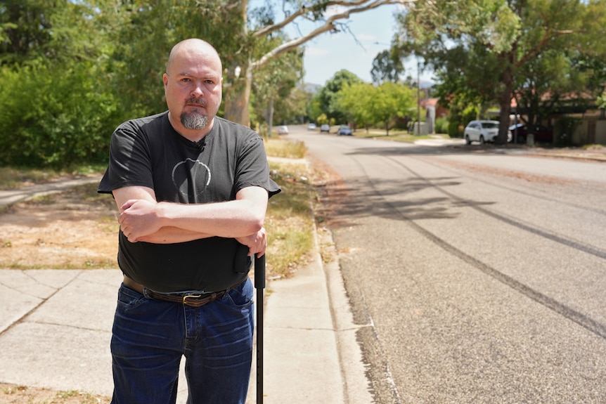 A man crosses his arms and looks angry.