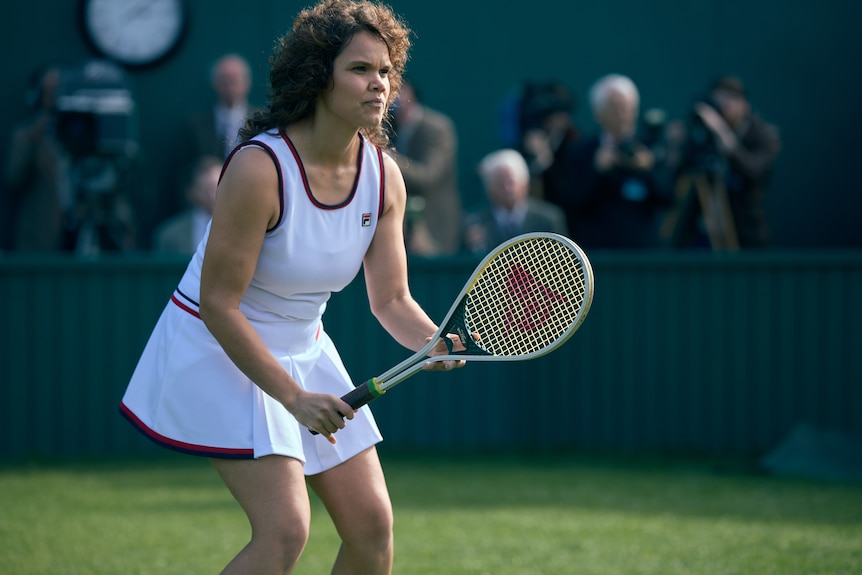 Lila as Evonne gets ready to receive a serve during a game of tennis.