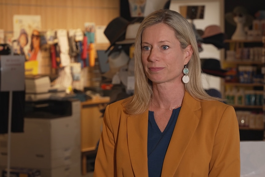 Rebecca White wears a mustard-coloured blazer and has blond hair and earrings