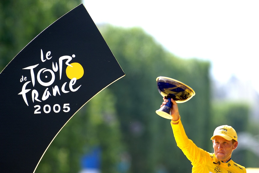 Lance Armstrong holds up a trophy