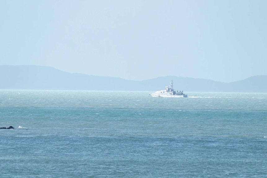 A powerful boat on the ocean, as seen through a haze.