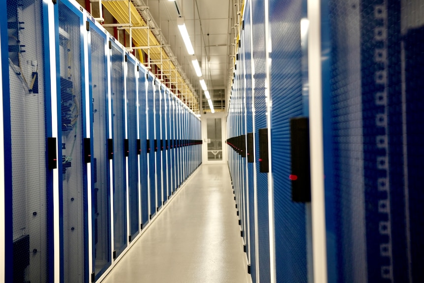 a long stretch of blue hallway in a sterile, brightly lit warehouse