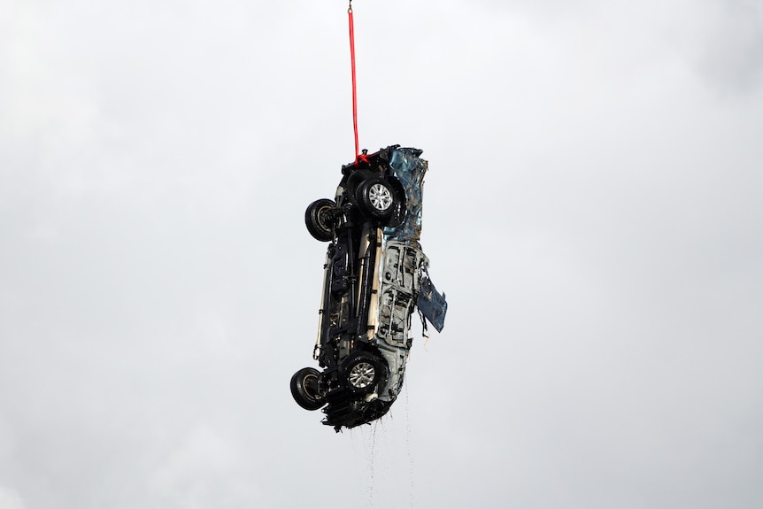 A car hanging from a rope.