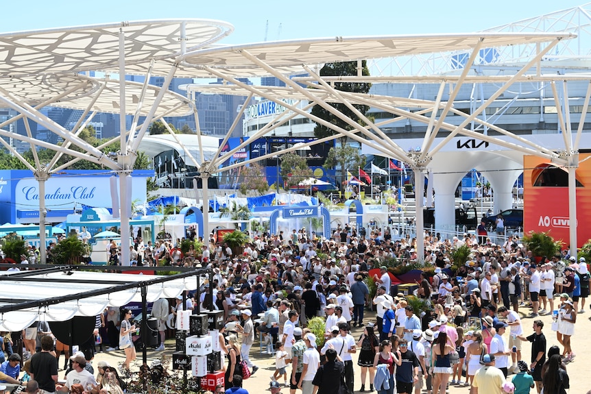 A crowd of people mulls around the outside of the arenas at the Aust Open in Melbourne.