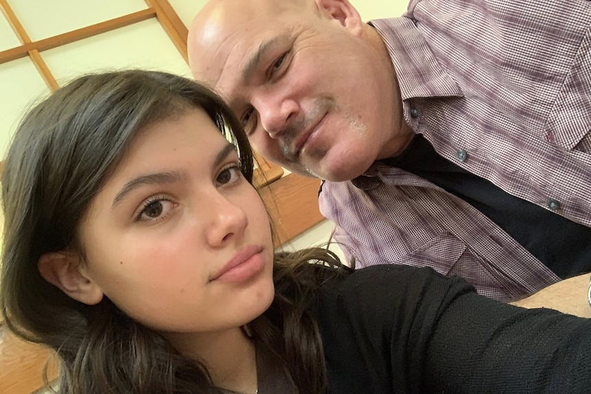 A man and a younger woman, his daughter, in a posed photo