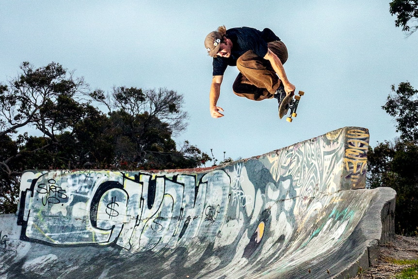 A skater jumps above a vert wall