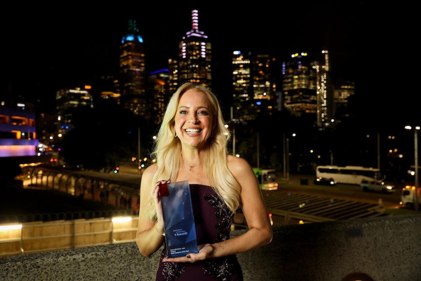 Carrie Bickmore holding an award.