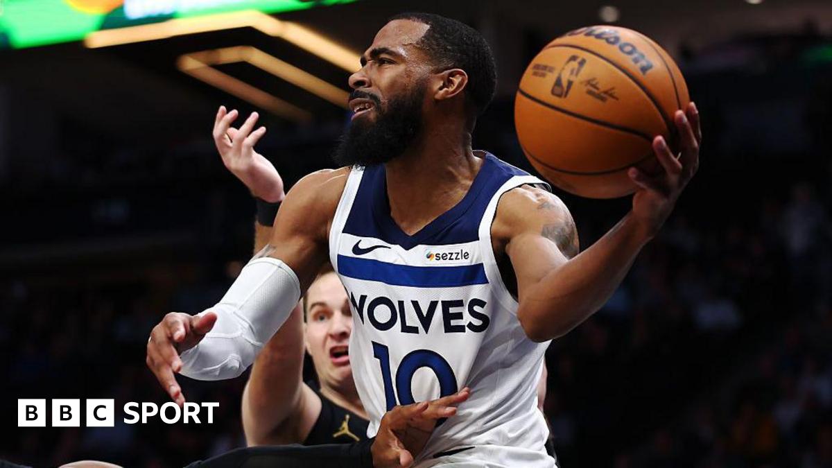 Mike Conley holds a basketball in his hand