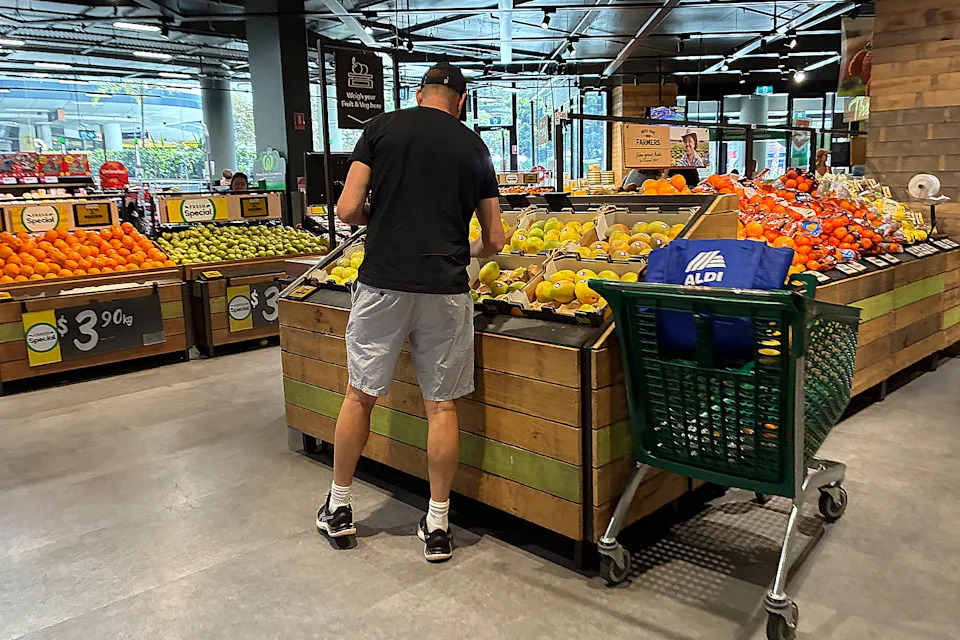 Man shops at Woolworths with trolley.