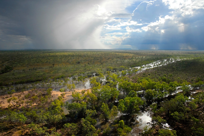 A storm front passes over a floodplain.