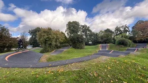 Karen Bull A child cycling on a rockpool with cloudy skies and tried in the background