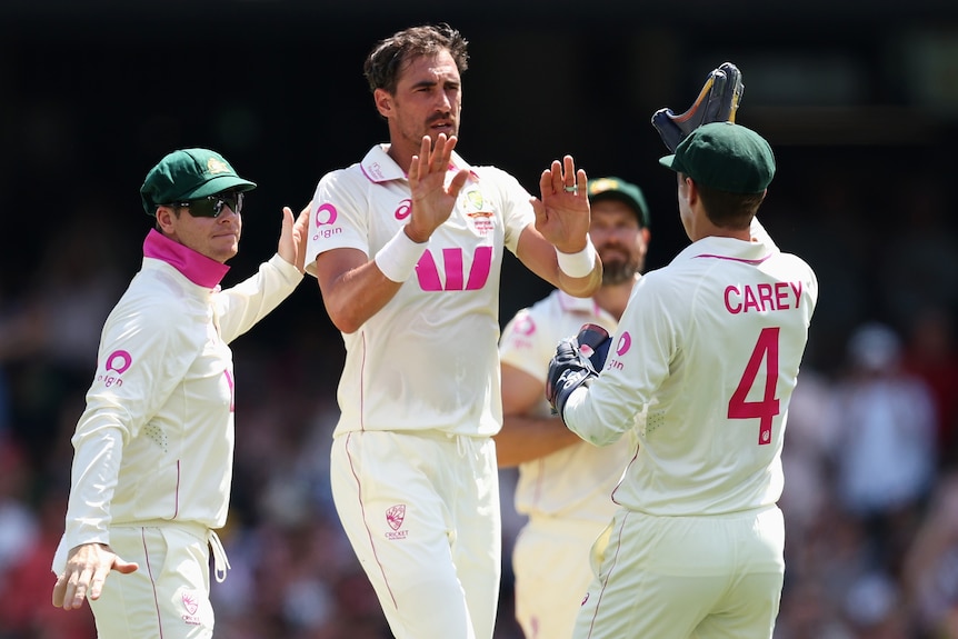 Mitchell Starc is congratulated by Australia teammates after the wicket of Ben Duckett.