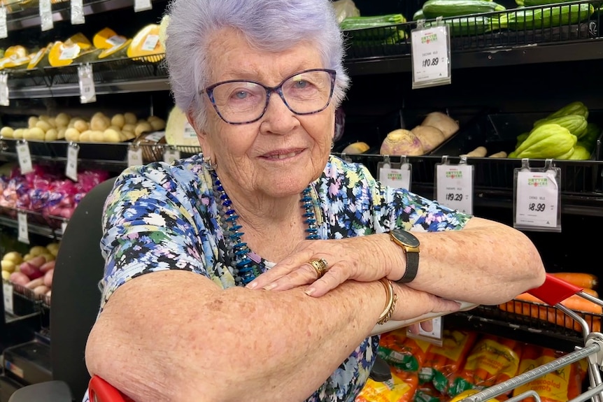 Woman in supermarket in front of fruit and vegetables.