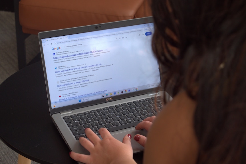 A woman on a laptop searching for information about Shincheonji