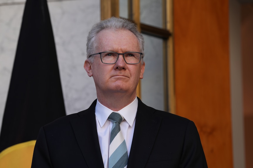 A man wearing a suit and glasses.