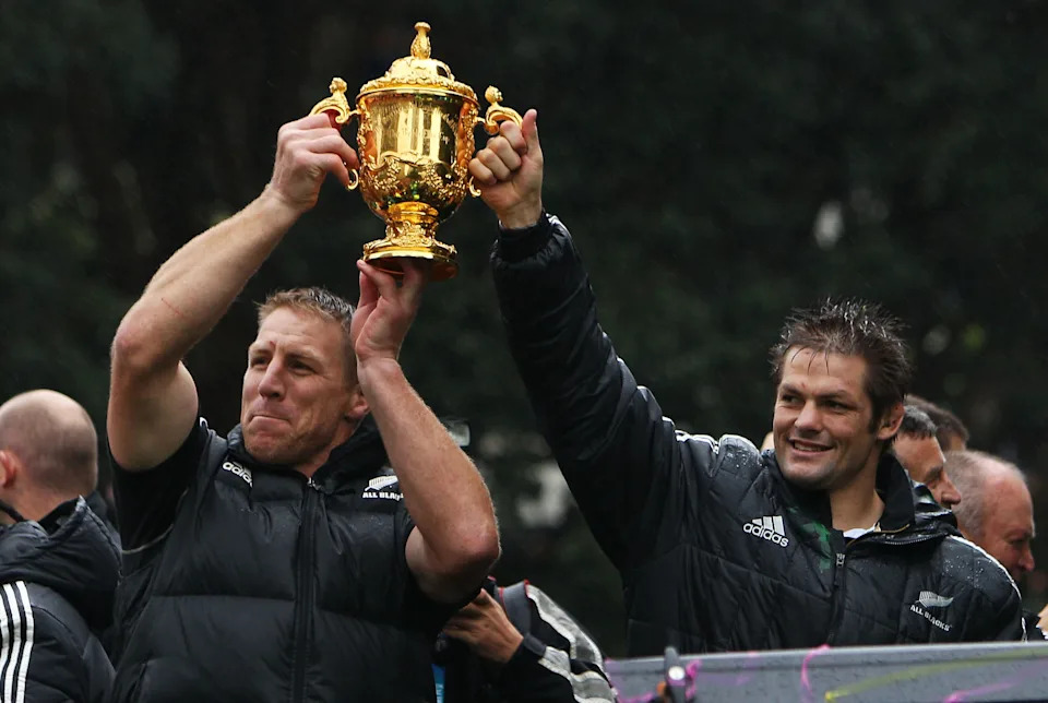 Pictured left to right, Brad Thorn and All Blacks legend Richie McCaw hold the Rugby World Cup trophy aloft in 2011.