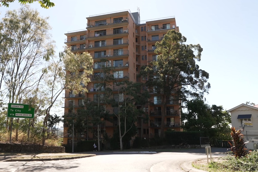 Brown brick building with road sign nearby.